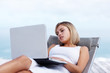 Young female online browsing , relaxing on a recliner