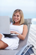 Happy young female online browsing , relaxing on a recliner