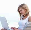 Photo: Lovely female using a laptop while sitting outdoors Lovely female using a laptop while sitting outdoors