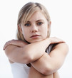 Cute young female sitting calmly against white