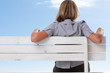 Rear view of a female sitting isolated on a bench