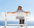 Rear view of a young woman sitting isolated on a bench