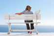Rear view of a young woman sitting isolated on a bench