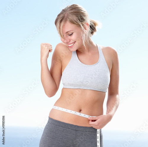 Photo: Happy young woman on success of a weight loss Happy young woman on success of a weight loss