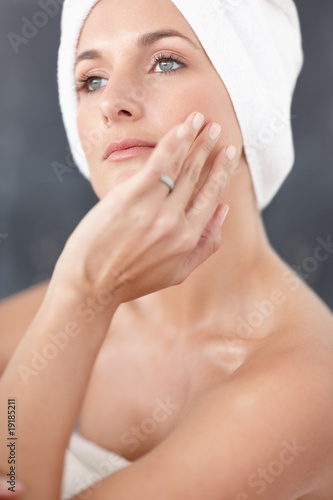 Photo: Pretty young female contemplating , bathroom view Pretty young female contemplating , bathroom view