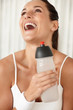 Laughing woman with a bottle of water after a workout