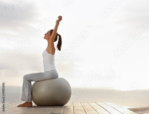 Photo: Fitness woman exercising on a ball outdoors Fitness woman exercising on a ball outdoors