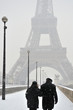 couple de touriste devant la tour eiffel sous la neige
