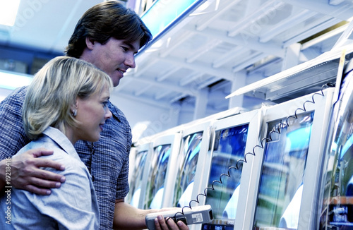 Photo: Couple looking at televisions Couple looking at televisions