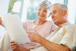 Senior man and woman reading documents at their house