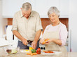 Retired elderly couple cooking food together in the kitchen Retired elderly couple cooking food together in the kitchen
