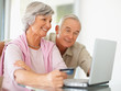 A senior couple shopping online using  laptop