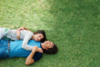 Top view of a happy young couple lying on grass