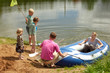 The family from five persons sits down in an inflatable boat
