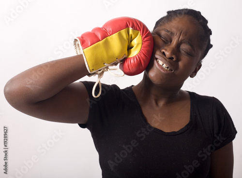 Photo: femme noire se donne un coup de poing gant de boxe femme noire se donne un coup de poing gant de boxe