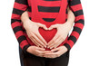 Heart from hands on the pregnant woman