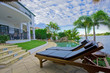 Deck chairs by the pool at waterfront mansion