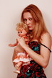 Sad young woman clutching doll