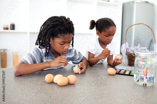 Foto: Concentrated Afro-american siblings painting eggs Concentrated Afro-american siblings painting eggs