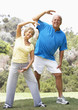 Senior Couple Exercising In Park