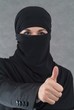 Erfolgreiche muslimische Frau im Burka zeigt Finger nach oben.