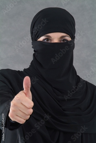 Foto: Eine muslimische Frau im Burka zeigt Finger nach oben. Eine muslimische Frau im Burka zeigt Finger nach oben.