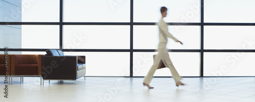 Photo: Businesswoman walking through office waiting area Businesswoman walking through office waiting area
