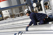 oil-worker climbing on pipelines