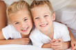 Adorable siblings playing on a bed Adorable siblings playing on a bed