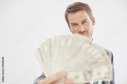 Photo: Man with a fan made of dollars Man with a fan made of dollars