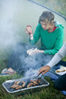 Two young men cooking sausages on a barbecue