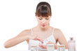 Body care: Young woman applying lotion in bathroom