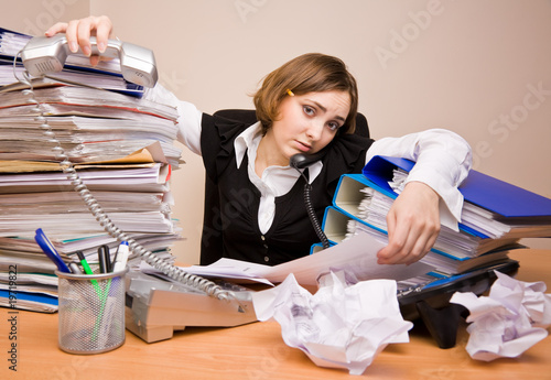 Photo: Young businesswoman with tons of documents Young businesswoman with tons of documents