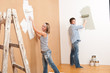 Home improvement: Young couple painting wall
