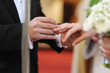 Groom putting a ring on bride's finger