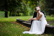 Bride and groom are sitting in autumn park