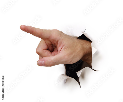 Hand zeigt durch Loch in Papierwand