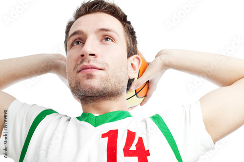 Photo: Basketball player standing with ball behind his head looking up. Basketball player standing with ball behind his head looking up.