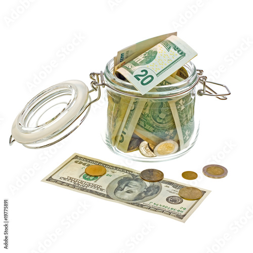 Photo: Different money in the glass jar isolated on white Different money in the glass jar isolated on white