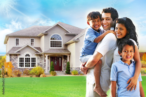 Photo: Happy family portrait in front of house Happy family portrait in front of house