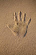 main dans le sable