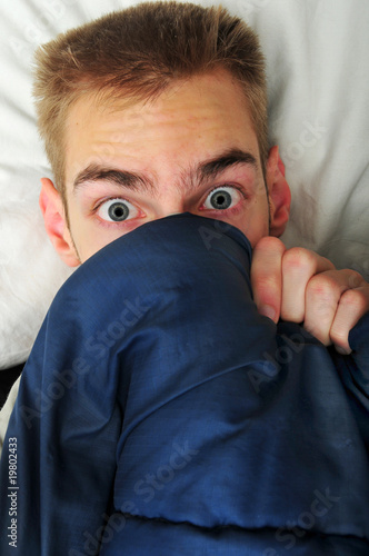 Photo: Young adult teen hides under covers Young adult teen hides under covers