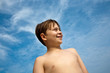 happy smiling young boy with brown hair and eyes at the beach