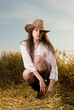 Beautiful slavonic girl in cowboy clothes pose in wheat field