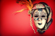 Ornate carnival mask over red background