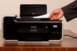 Hand placing paper in photocopier