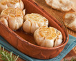 Garlic roasting in olive oil in a clay pot Garlic roasting in olive oil in a clay pot