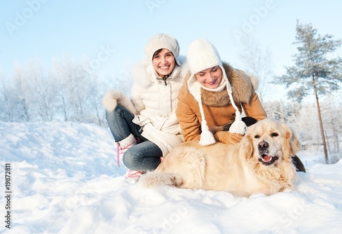 Foto: Friends playing with golden retriever outdoors Friends playing with golden retriever outdoors