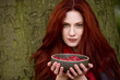 A young woman holding a bowl of raspberries