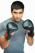Young guy with boxing gloves against white